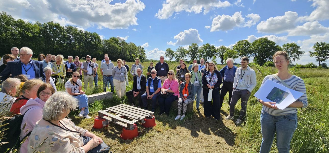 Die Teilnehmer des LEADER-tags sitzen gemeinsam in einer Wiese